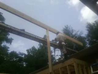 Carpenter setting a ridge beam over a new addition frame — Ice Dam Removal by Roofing Brothers in Medinah