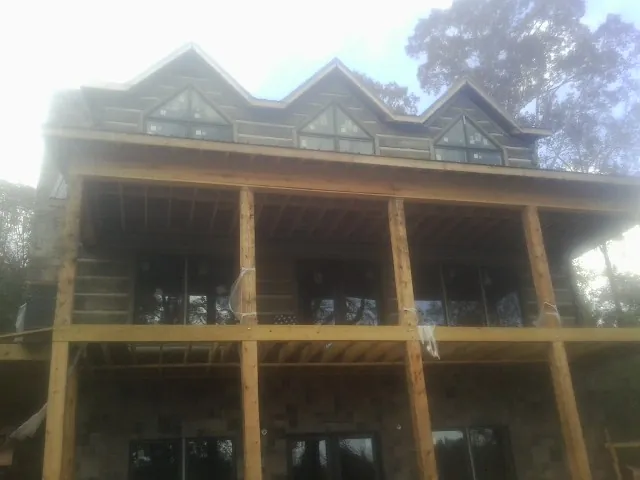 Dormers and porch framing on a large log home under construction — Roof Coating work by our crew in Medinah
