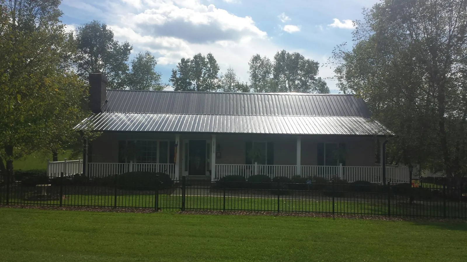 Gray metal roof on a brick ranch with a full width front porch — Gutter Guard Installation work by our crew in Medinah